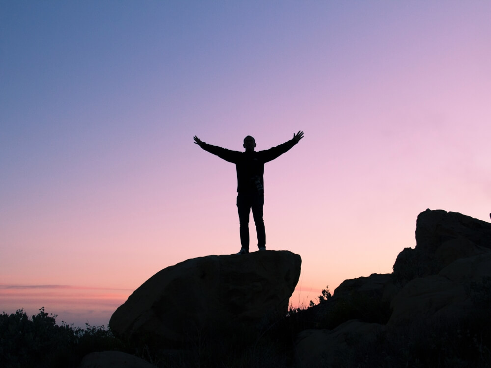 Substance Abuse Treatment in Tucson with Evolved LLC image of a man ontop of a rock.